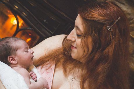 picture of morristown doula Cindy holding baby with a fireplace in the background.  hackettstown doula hackettstown birth doula hackettstown birth support