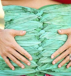 bengkung belly bind in light greens and blues wrapped, hands on abdomen.  nj malaysian belly bind, mount olive belly binding